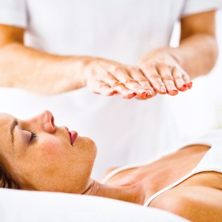 Tu Salud Consciente. Young woman receiving reiki treatment