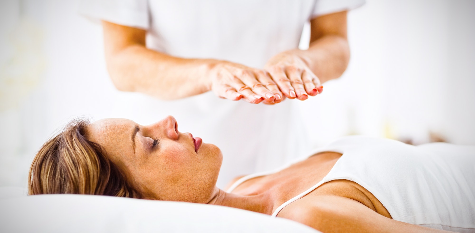 Tu Salud Consciente. Young woman receiving reiki treatment